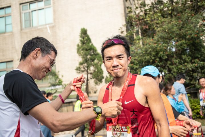 許績勝老師(左)為男子組全馬第二名方柏偉(右)頒發完賽獎牌。