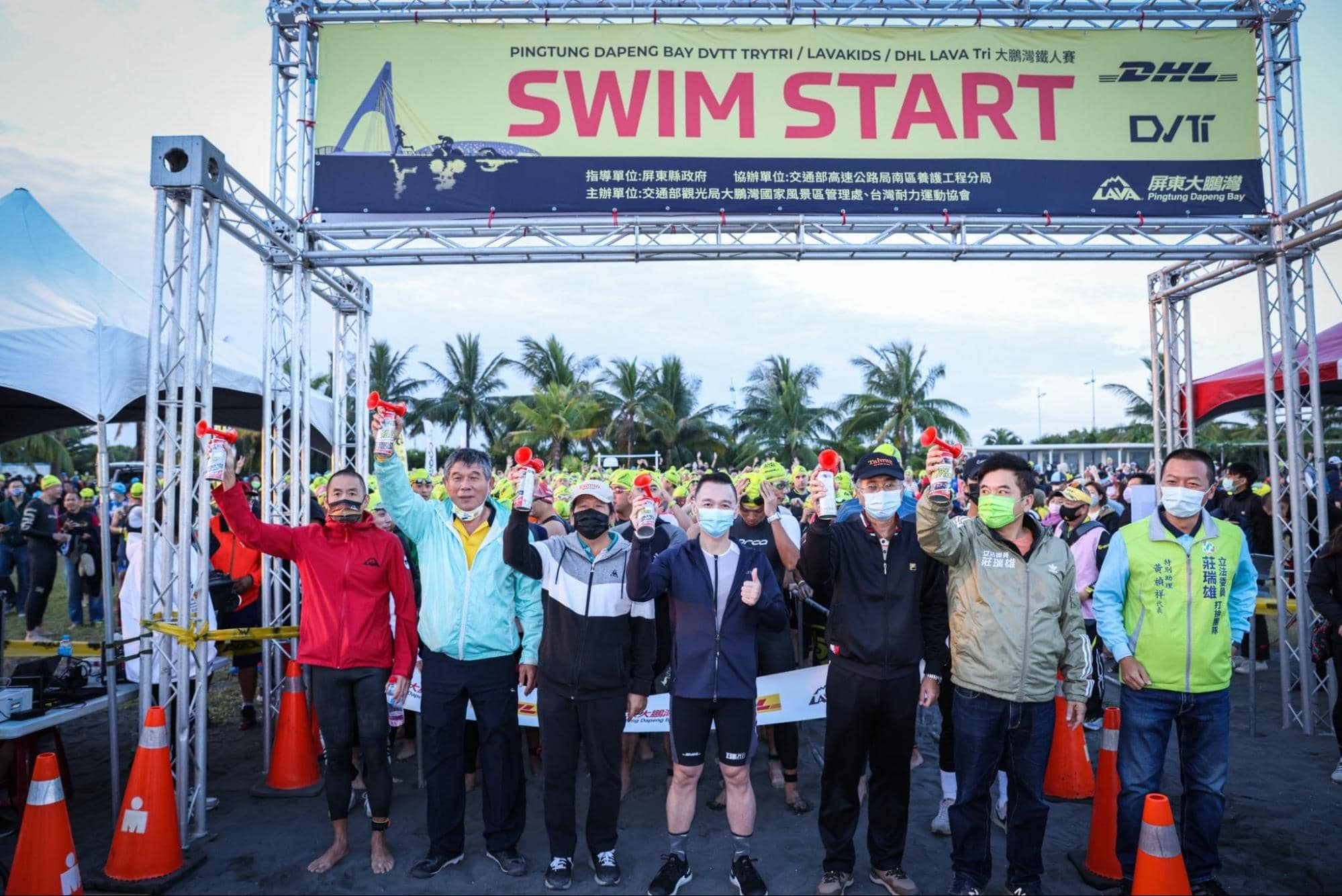 「2021 DHL LAVA TRI 鐵人賽大鵬灣站」在立法委員莊瑞雄(右二)、交通部觀光局大鵬灣國家風景區管理處郭進慶秘書(右三)、交通部觀光局大鵬灣國家風景區管理處蔡昌悅課長(左三)、立法委員莊瑞雄辦公室特別助理黃禎祥(右一)、崎峰社區發展協會甘景勻總幹事(左二)、DHL國際快遞台灣總經理黃湧君(右四)、LAVA台灣鐵人公司董事長林澤浩(左一),共同鳴笛下六點五十分準時開賽。